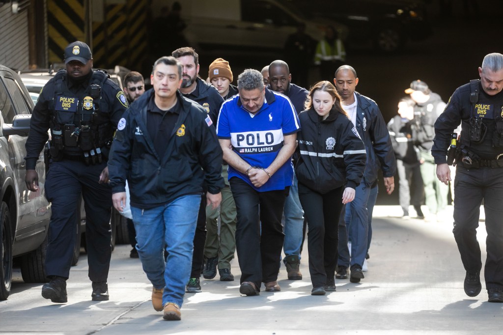Juan Mercado, center in the Polo shirt, is escorted by law enforcement out of 26 Federal Plaza in New York, Tuesday, Feb. 6, 2024.