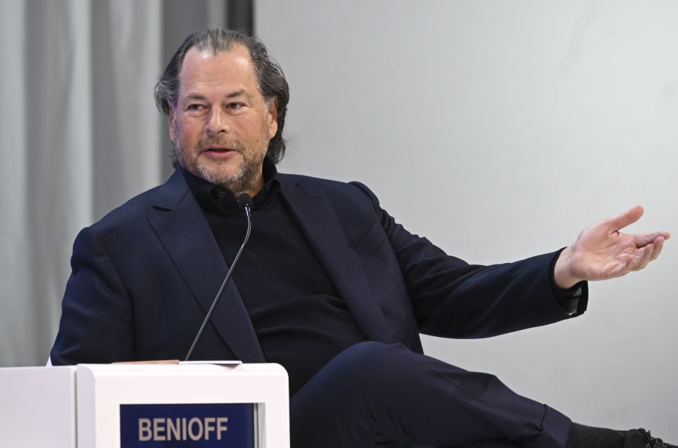 Man in suit speaks into microphone at panel 