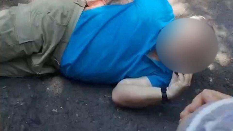 A man lies on the ground after a stabbing attack