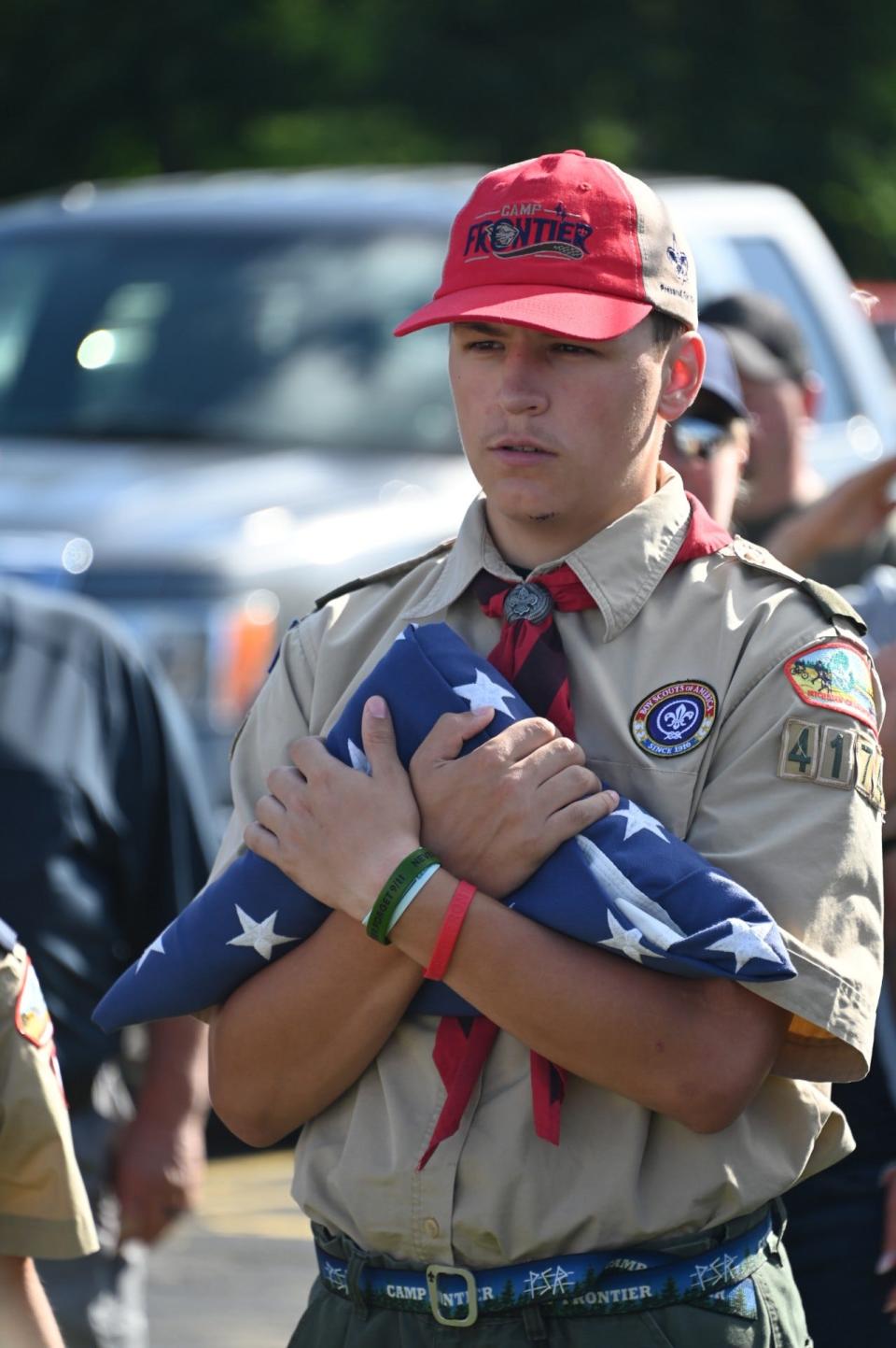 A Scout presents a flag for disposal.