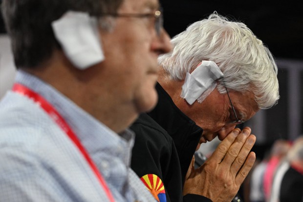 Attendees wear a patch over their ear in solidarity with US former President and 2024 Republican presidential candidate Donald Trump as they pray during the third day of the 2024 Republican National Convention at the Fiserv Forum in Milwaukee, Wisconsin, on July 17, 2024. (JIM WATSON/AFP via Getty Images)