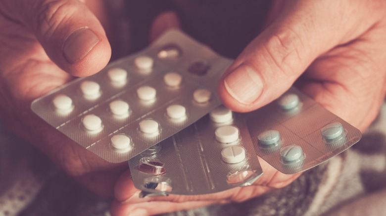 man's hands holding sheets of ibuprofen